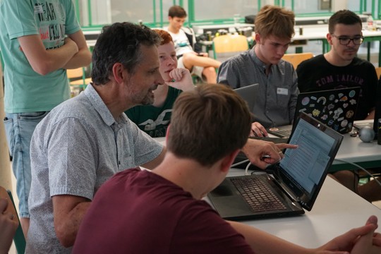 Schüler und Lehrer gemeinsam am Laptop
